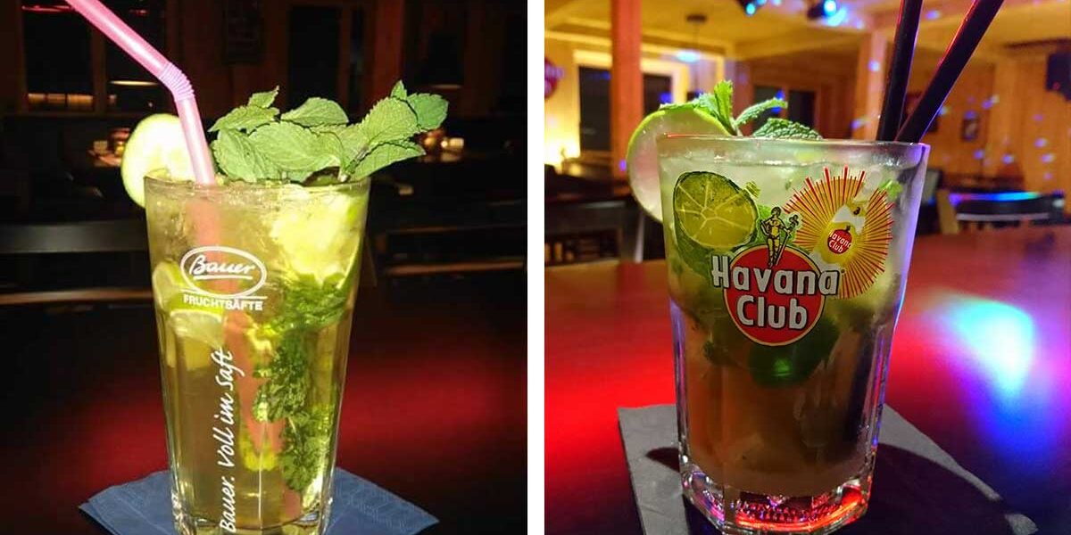 Zwei Mojito-Cocktails mit Minze, Limette und Strohhalmen stehen auf den Tischen in der schwach beleuchteten Kleiner Lord Bar.