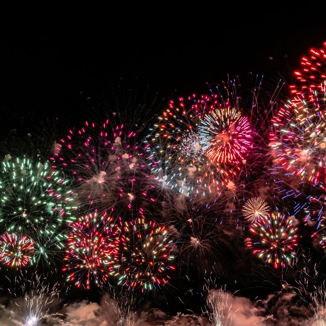 Ein farbenfrohes Feuerwerk, das über Rauchwolken in den Nachthimmel steigt, macht den Jahresausklang zu Silvester 2026 zu einem unvergesslichen Erlebnis.